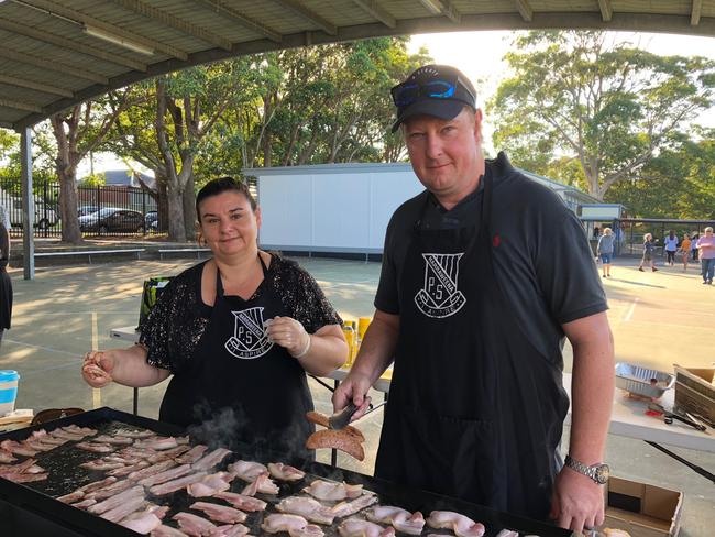 Volunteer cooks, Nicole Adler and Andrew Lambert, at the P &amp; C fundraising barbecue at Narraweena Public School. 