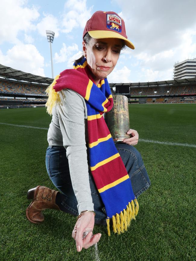 Brisbane Lions supporter Sandra Perrett spreads the ashes of her late husband on the Gabba. Picture: Liam Kidston