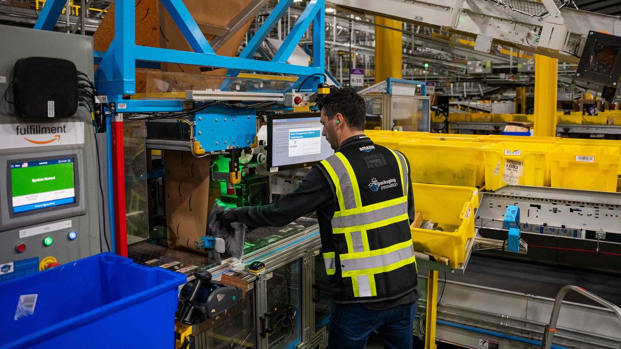 An Amazon employee works at a new packaging station at MQY1. Picture: Seth Herald/AFP