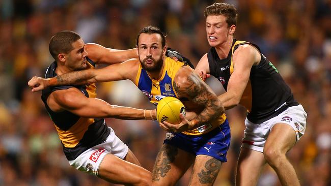 Shaun Grigg and Connor Menadue try to tackle West Coast’s Chris Masten, who is still able to get a handball away. Picture: Getty Images