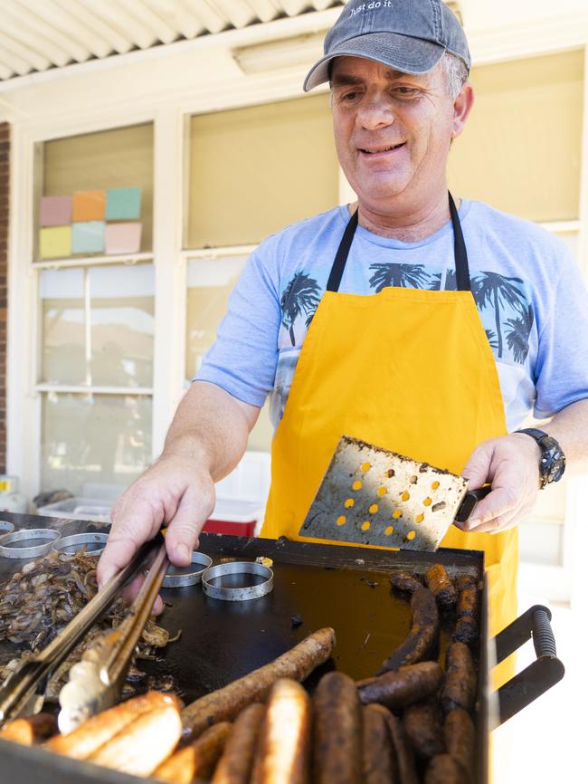 Jeff Oehlman cooking the democracy sausages at Panania Public School. Picture: Matthew Vasilescu