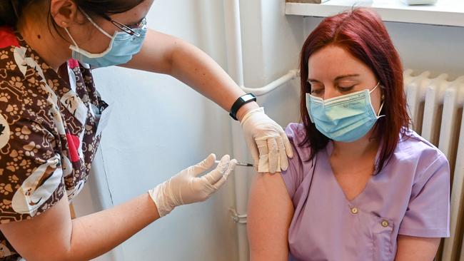 A nurse, right, gets her second dose of the Pfizer-BioNTech vaccine against COVID-19 in a medical centre in the EU nation of Hungary last week. Picture: Attila Kisbenedek / AFP