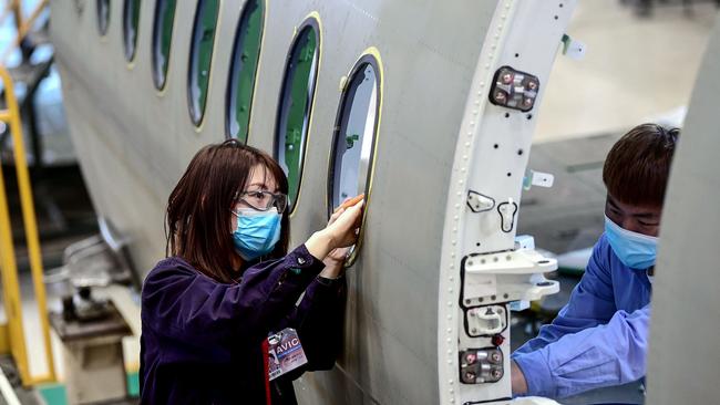 Chinese employees work on an aircraft at a factory in Shenyang. Picture: AFP
