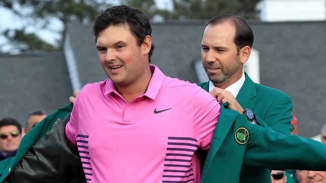 TOPSHOT - AUGUSTA, GA - APRIL 08: Patrick Reed of the United States is presented with the green jacket by Sergio Garcia of Spain during the green jacket ceremony after winning the 2018 Masters Tournament at Augusta National Golf Club on April 8, 2018 in Augusta, Georgia.   David Cannon/Getty Images/AFP / AFP PHOTO / GETTY IMAGES NORTH AMERICA / DAVID CANNON