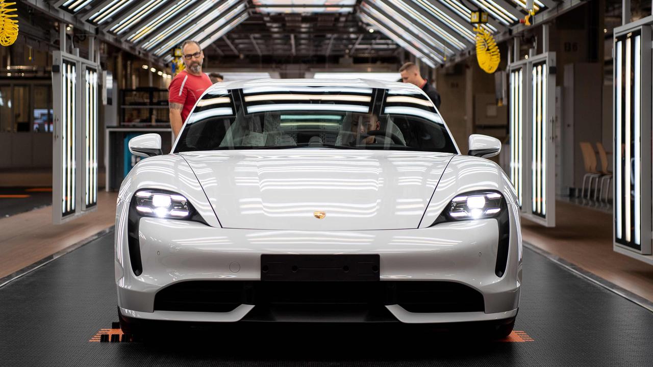 A Porsche Taycan electric car gets an inspection before rolling off the production line.