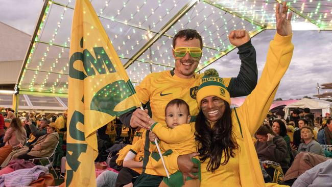 Finnick Bollenhagen at eight months is one of the youngest fans in Adelaide, cheering on the Matildas with parents Daniel and Krupa. Picture: NCANewsWire / Kelly Barnes