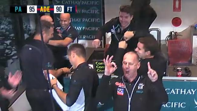 Screenshots of Port Adelaide coach Ken Hinkley celebrating Port Adelaide's win over Adelaide in Showdown 44. Hinkley is seen gesturing the numbers 1-0 in reference to Port ending its Showdown losing streak.