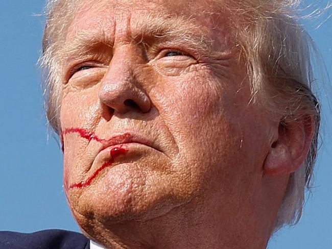 TOPSHOT - BUTLER, PENNSYLVANIA - JULY 13: Republican presidential candidate former President Donald Trump pumps his fist as he is rushed offstage during a rally on July 13, 2024 in Butler, Pennsylvania. Butler County district attorney Richard Goldinger said the shooter is dead after injuring former U.S. President Donald Trump, killing one audience member and injuring another in the shooting.   Anna Moneymaker/Getty Images/AFP (Photo by Anna Moneymaker / GETTY IMAGES NORTH AMERICA / Getty Images via AFP)