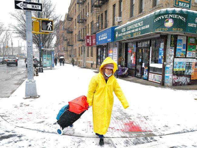 A woman crosses the street as snow falls in the Brooklyn borough of New York City on January 6, 2025. Picture: AFP