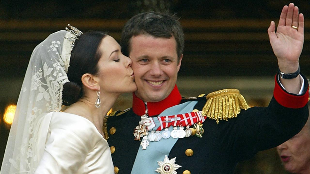 Crown Princess Mary of Denmark kisses her husband Danish Crown Prince Frederik on the balcony at Amalienborg Castle in Copenhagen following their wedding ceremony in 2004.