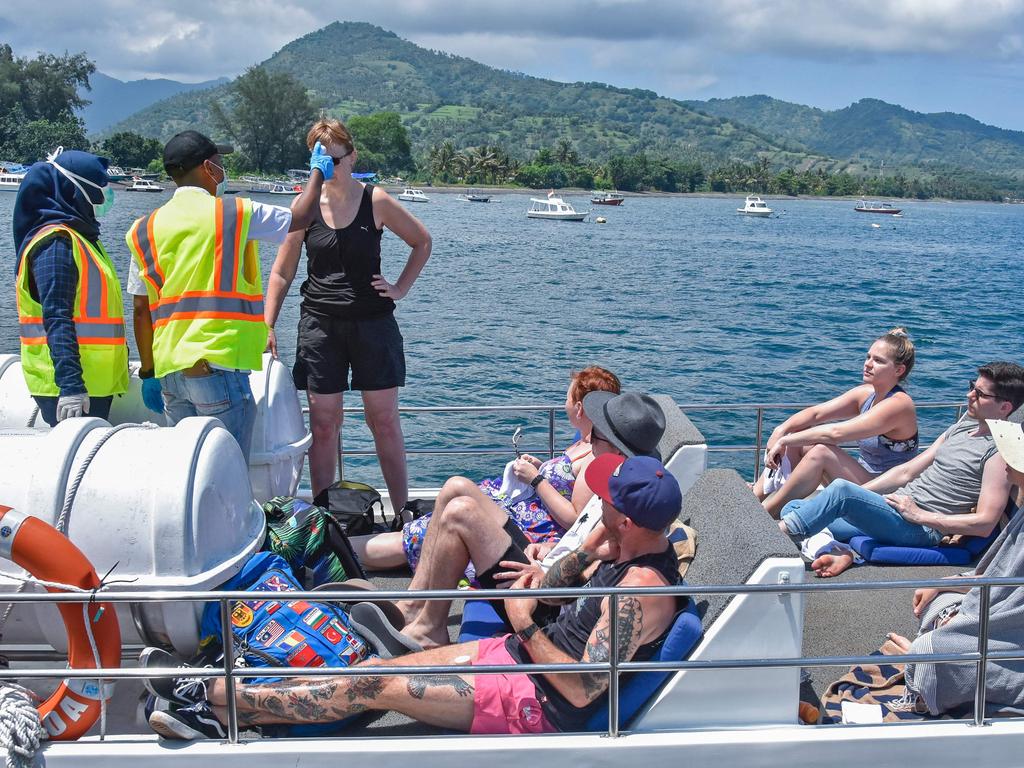 Indonesian health officials check the temperature of foreign tourists heading to Gili Trawangan in February, before Indonesia closed to international visitors. Picture: Moh el Sasaky/AFP