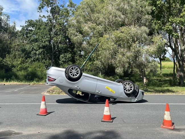 Car upside down after light pole crash