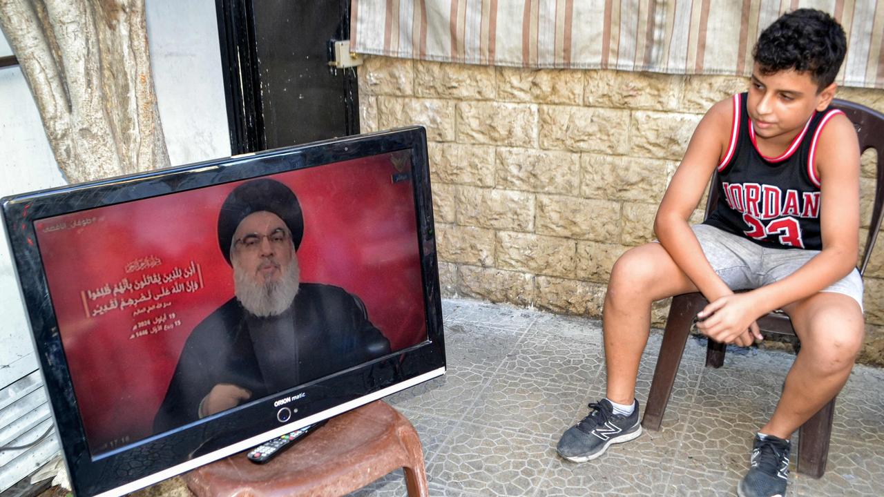 A boy sits next to a television set airing a speech by the leader of the Lebanese Shiite movement Hezbollah Hassan Nasrallah at a cafe in the Jabal Mehsen neighbourhood of Lebanon's northern city of Tripoli on September 19, 2024. (Photo by Fathi AL-MASRI / AFP)