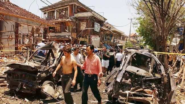 A foreigner being assisted by a local after surviving the Bali bombing.