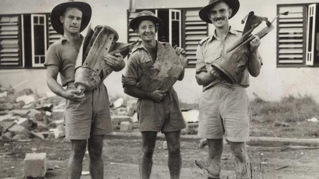 Pte F. Conlin of Sydney, Driver J. Hankin of Sydney, and Sergeant Babb of Balgownie are holding parts of Japanese bombs dropped during the raid on Darwin.