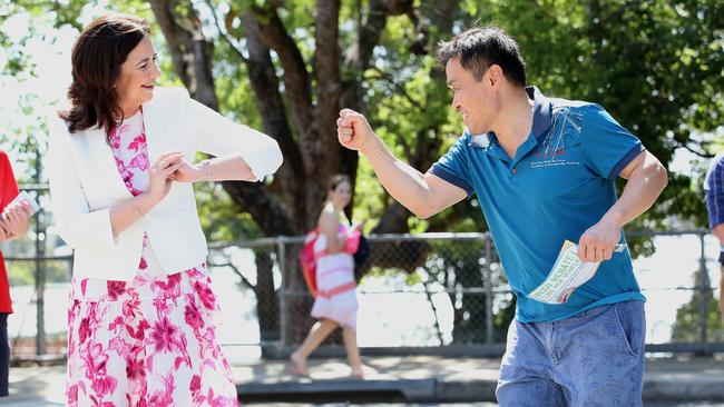 Queensland Premier Annastacia Palaszczuk does a socially distanced greeting with a voter at a polling booth in Brisbane on Saturday.