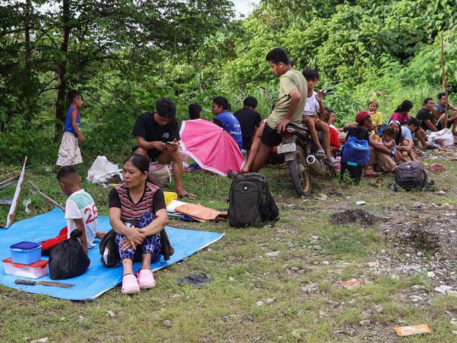 Residents rest on a roadside serving as temporary shelter as they experience frequent aftershocks at a village in the Hinatuan town after a 7.6 earthquake struck the province. (Photo by AFP)