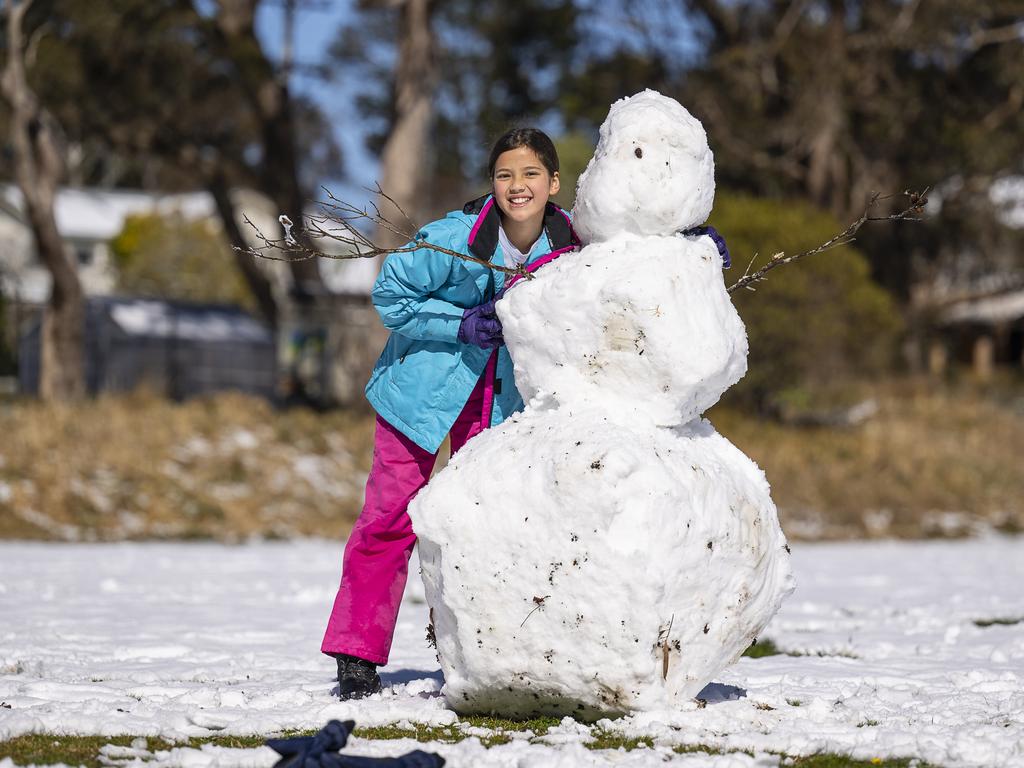 Snow has fallen across the Blue Mountains overnight. Georgie Putra. in Katoomba with a giant snowman. Picture Simon Carter