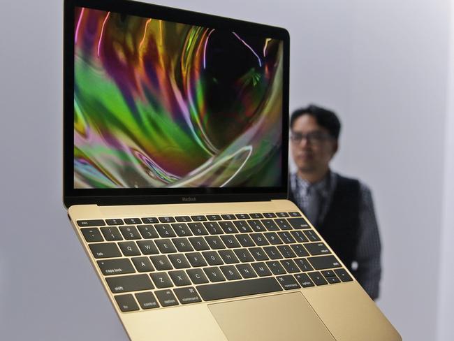 FILE - In this March 9, 2015 file photo, members of the media and Apple guests get a look at the new MacBook in the demo room after an Apple event in San Francisco. The company will debut the new laptop on Friday, April 10, 2015. (AP Photo/Eric Risberg, File)