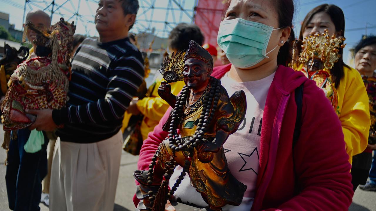 Taiwanese people wearing protective masks arrive at the Taoist Longde temple during a ceremony to prevent the COVID-Coronavirus in Taoyuan on February 15 2020. Picture: Sam Yeh/AFP