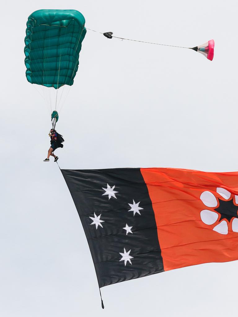 Skydivers bring down a giant Territory flag at the funeral for local Civil Engineer and TV Star Chris ‘Willow’ Wilson at the Darwin Convention centre. Picture: Glenn Campbell