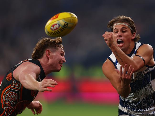 Jhye Clark handballs under pressure from Tom Green. Picture: Graham Denholm/Getty Images