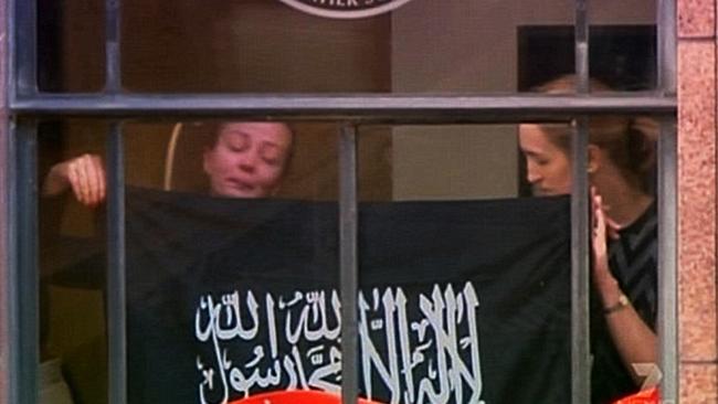 Survivor Marcia Mikhael in the window of the Lindt Cafe during the siege with Katrina Dawson (right) who was killed as the standoff came to an end.
