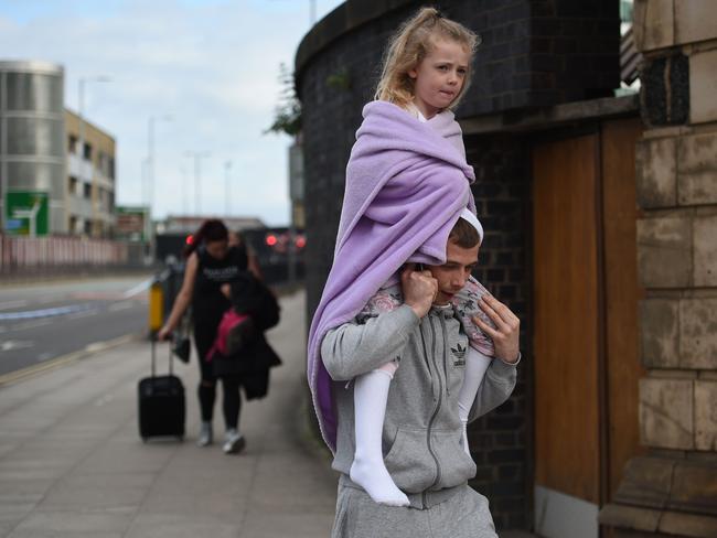 A man carries a young girl on his shoulders near Victoria station in Manchester after the attack. Picture: AFP
