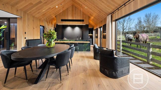 The dining room and stylish kitchen at the main house, which also features floor-to-ceiling glass windows looking out onto the horse paddocks.