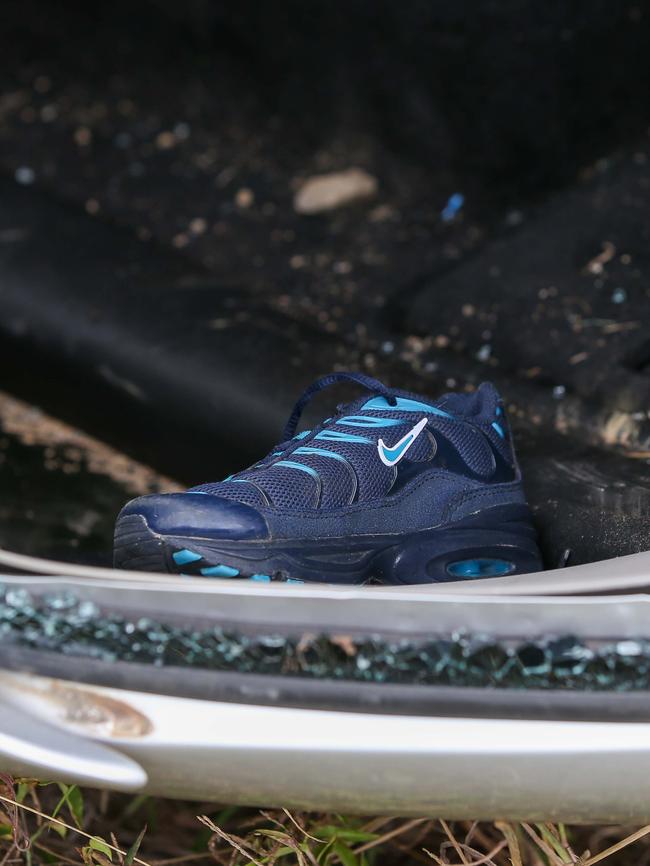 A sports shoe lies in the wreckage of the car.