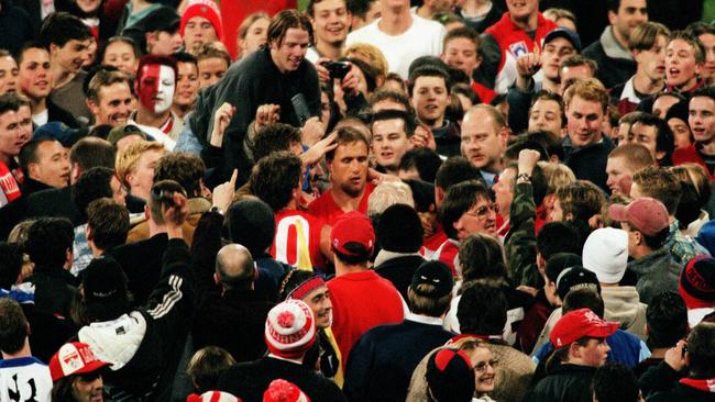 Fans surround Tony Lockett after kicking his 100th goal for the season for the Swans in 1998. Picture: Herald Sun