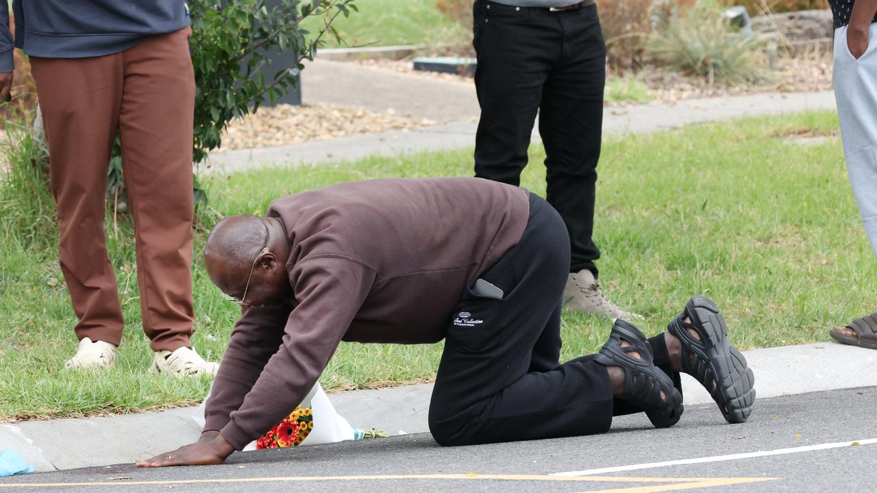 Samuel Mwanza collapses at the Wyndham Vale bus stop where his son was killed. Picture: David Crosling