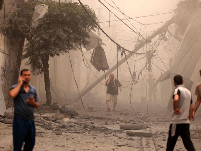 Palestinians inspect the destruction in a neighbourhood heavily damaged by Israeli air strikes on Gaza City’s Shati refugee camp early on October 9.