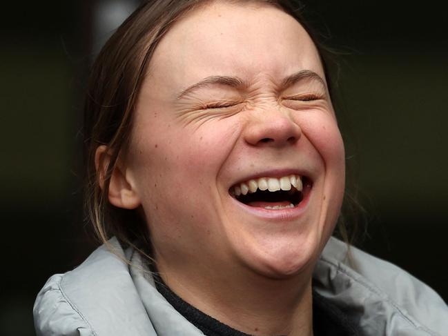 Swedish environmental activist Greta Thunberg laughs as she and fellow defendants and supporters return to Westminster Magistrates Court in London on February 2, 2024, on the second day of their public order offence trial. Activist Greta Thunberg defied police orders to move during a climate demonstration, prosecutors told a London court on Thursday, on the first day of her two-day trial for public order offences. (Photo by Daniel LEAL / AFP)