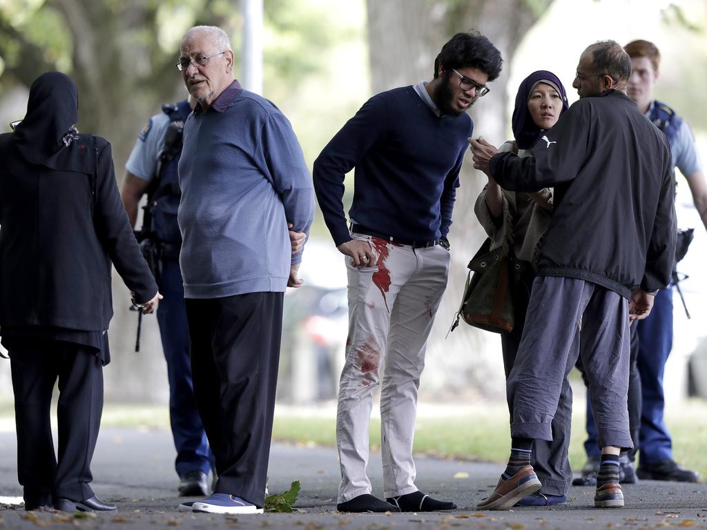 People stand across the road from a mosque in central Christchurch, New Zealand, Friday, March 15, 2019. (AP Photo/Mark Baker)