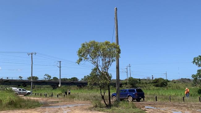 Police and Aurizon on scene where a teenage boy was electrocuted after climbing and swinging off a power pole near the train bridge across Auckland Creek.