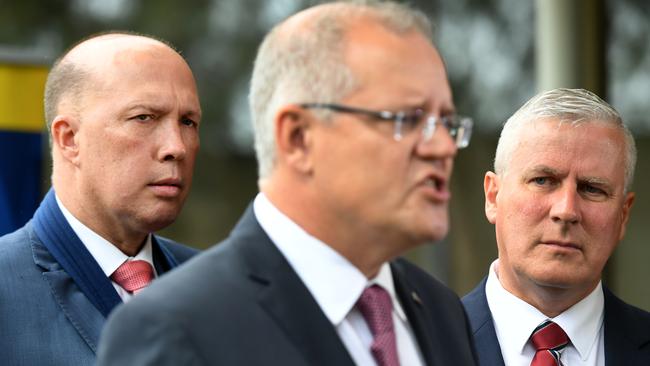 Deputy Prime Minister Michael McCormack (right) and Minister for Home Affairs Peter Dutton (left) with Australian Prime Minister Scott Morrison during a press conference in Bridgeman Downs this morning. Picture: AAP/Dan Peled