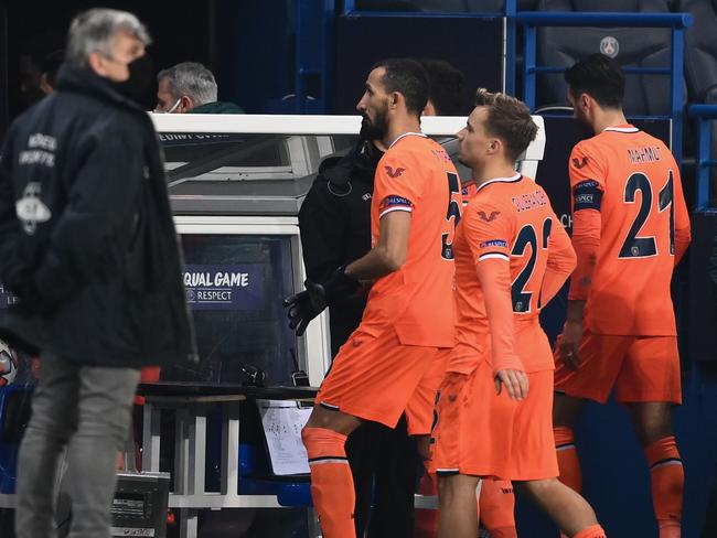 Istanbul Basaksehir's players leave the pitch after the game was suspended amid allegations of racism by one of the match officials during the UEFA Champions League group H football match between Paris Saint-Germain (PSG) and Istanbul Basaksehir FK at the Parc des Princes stadium in Paris, on December 8, 2020. - Paris Saint-Germain's decisive Champions League game with Istanbul Basaksehir was suspended today in the first half as the players walked off amid allegations of racism by one of the match officials. The row erupted after Basaksehir assistant coach Pierre Webo, the former Cameroon international, was shown a red card during a fierce row on the touchline with staff from the Turkish club appearing to accuse the Romanian fourth official of using a racist term. (Photo by FRANCK FIFE / AFP)