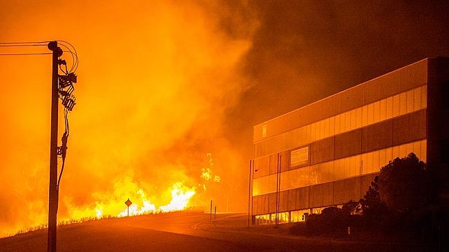 A bushfire burns out of control in the Southern Circuit industrial estate.