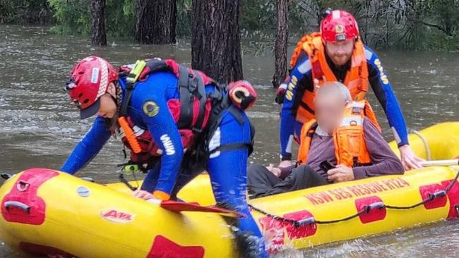 SES personnel rescue a man from floodwaters in the Liverpool area. Picture: Liverpool SES