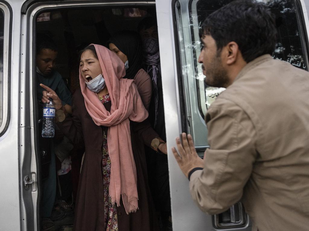 A woman yells for her family to hurry up as displaced Afghans from the northern provinces are evacuated from a makeshift IDP camp in Share-e-Naw park to various mosques and schools on August 12, 2021 in Kabul, Afghanistan. Picture: Paula Bronstein/Getty Images