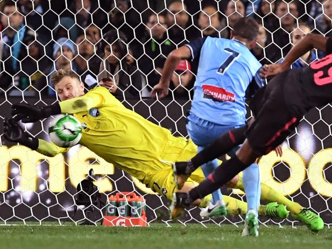 Arsenal player Joe Willock's (R) shot on goal is blocked by Sydney FC goalkeeper Andrew Redmayne (L) as Michael Zullo (C) looks on in their football friendly played in Sydney on July 13, 2017. / AFP PHOTO / WILLIAM WEST / -- IMAGE RESTRICTED TO EDITORIAL USE - STRICTLY NO COMMERCIAL USE --