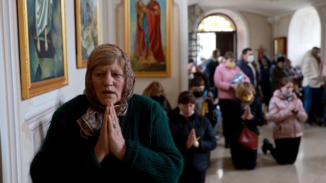 People pray as they seek shelter in a church after an air raid siren sounded as they visited an Israeli field hospital in Mostyska, Ukraine. Picture: Getty Images