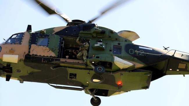 Australian Army aircrewman scans the ground from a 5th Aviation Regiment MRH90 Taipan helicopter, during Exercise Care Bear at James Cook University oval in Townsville, Queensland. *** Local Caption *** Exercise Care Bear is a 5th Aviation Regimentâs community engagement initiative, where members of the regiment are able to support the Townsville University Hospital (TUH), specifically Brighter Lives.   The second activity involves an Australian Army MRH90 Taipan helicopter, landing at James Cook University oval where patients and families from Townsville University Hospital were able to fly above Townsville.