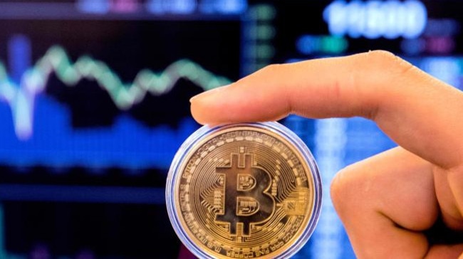 An Israeli holds a visual representation of the digital cryptocurrency Bitcoin, at the "Bitcoin Change" shop in the Israeli city of Tel Aviv. (Image: AFP/Jack Guez)