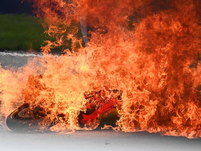 A motorbike is seen on fire after the riders escaped.