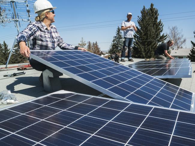 Workers installing solar panels on a residential homes roof.