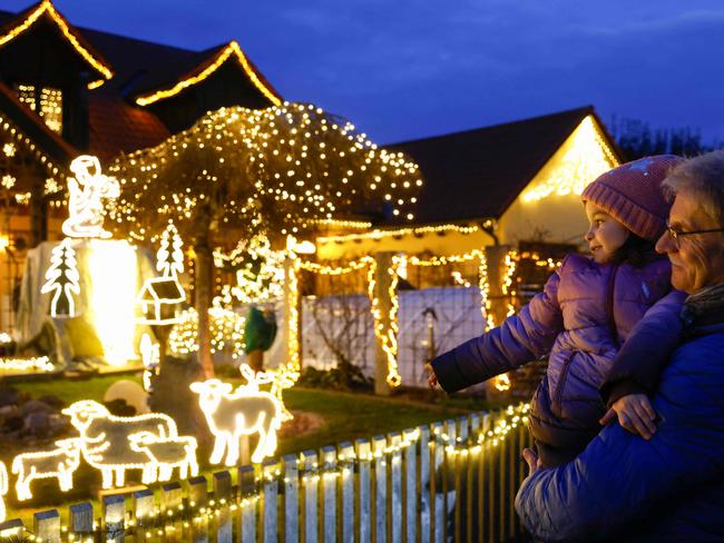 People admire Josef Glogger's Christmas-decorated house and garden, in Balzhausen near Guenzburg, southern Germany, on December 2, 2024. Glogger began his Christmas illumination 20 years ago, creating every figure himself. Now, his garden features 45,000 lights. He and his wife worked on this project together every year. After her death last year, Glogger decided to continue the tradition, spending six weeks setting it up and sending greetings to his wife in the sky. Over the past years, his decorations have attracted visitors and raised donations for cancer research. (Photo by Michaela STACHE / AFP)