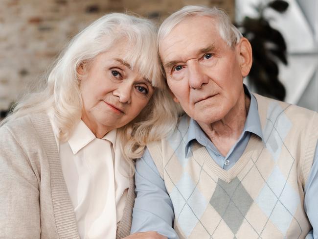 elderly couple hugging and sitting at home on quarantine; retirees, seniors generic