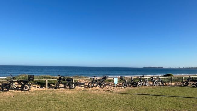 Seven flashy e-bikes are seen propped up against a barrier at a popular beach in Sydney. Picture: Daniel Peters / news.com.au